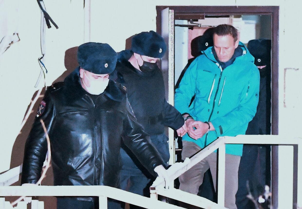 Сотрудники полиции выводят А. Навального из здания отдела полиции Управления МВД России по г. Химки, где прошел суд
