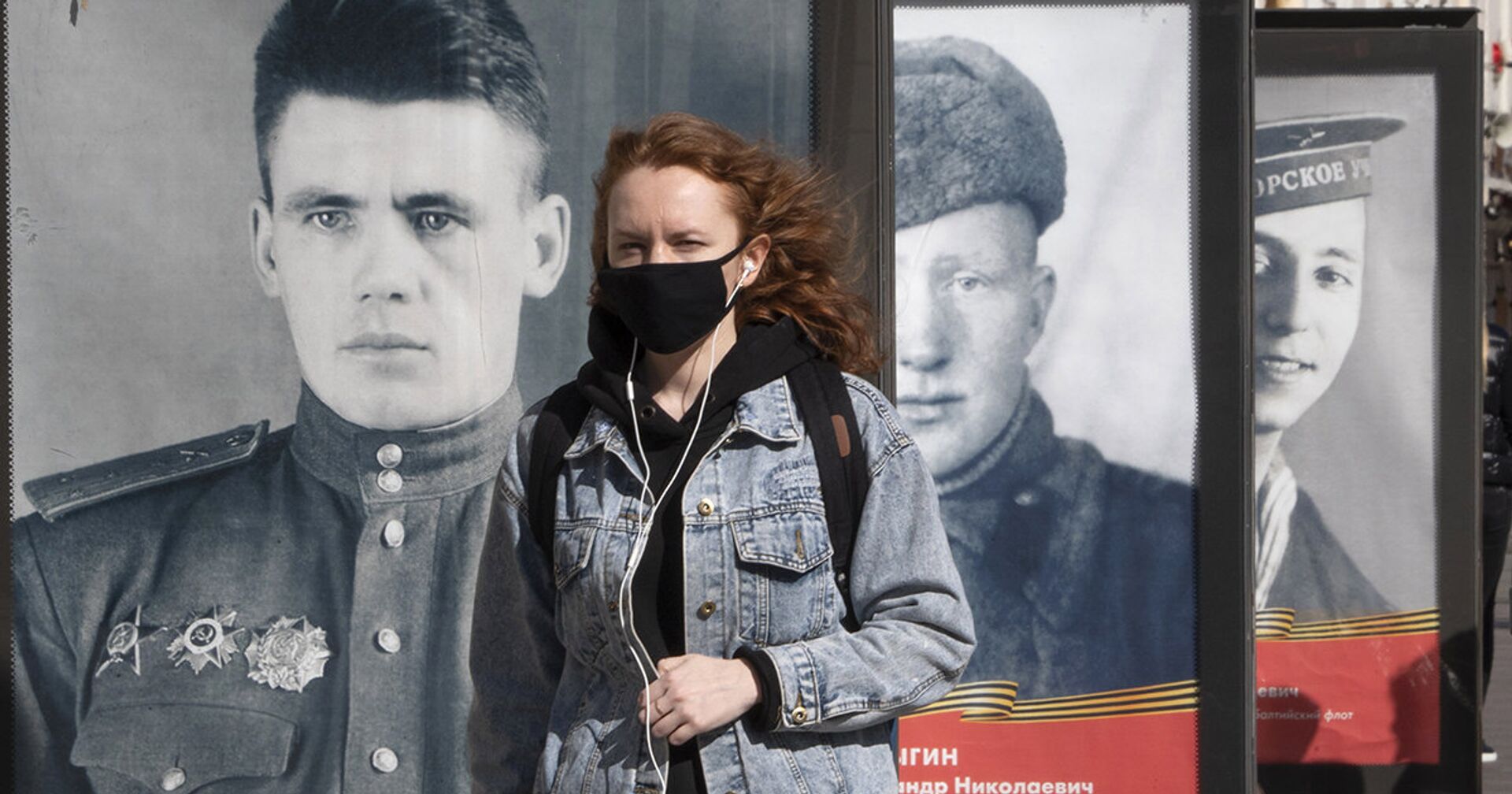 Женщина в маске идет мимо плакатов с портретами солдат Великой Отечественной войны - ИноСМИ, 1920, 21.01.2021