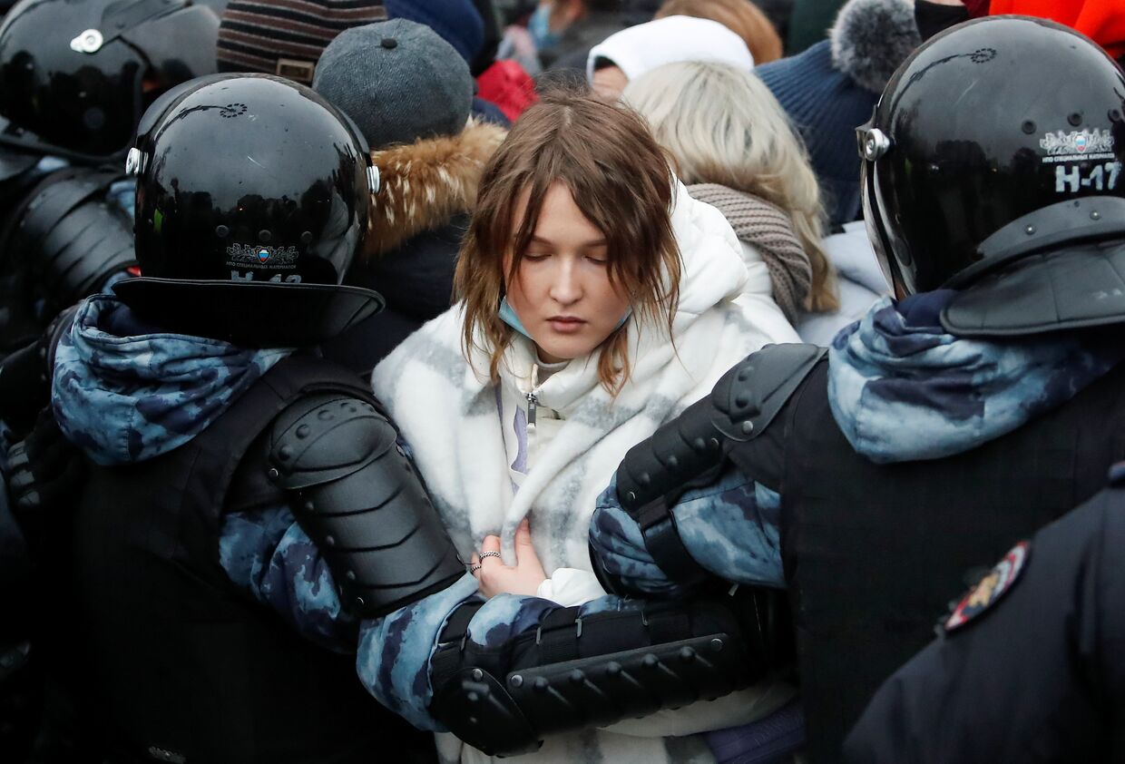 Полицейские держат участницу протестов в Москве