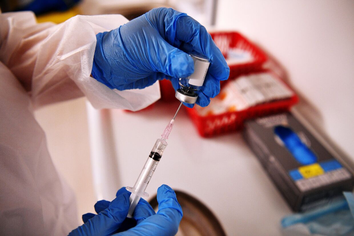 Медицинский сотрудник держит в руках вакцину «Спутник-V»