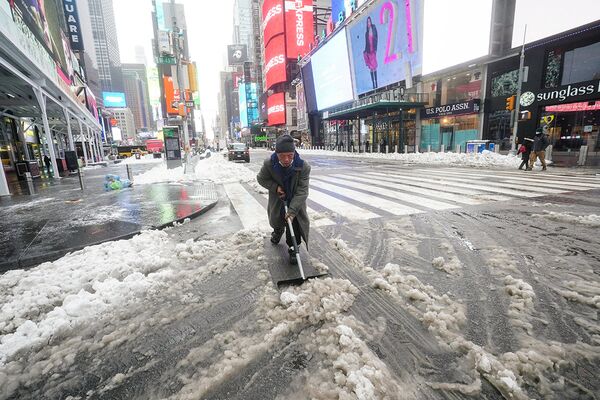 Мужчина убирает снег на Таймс-сквер в Нью-Йорке
