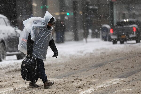 Прохожий во время снегопада в Нью-Йорке
