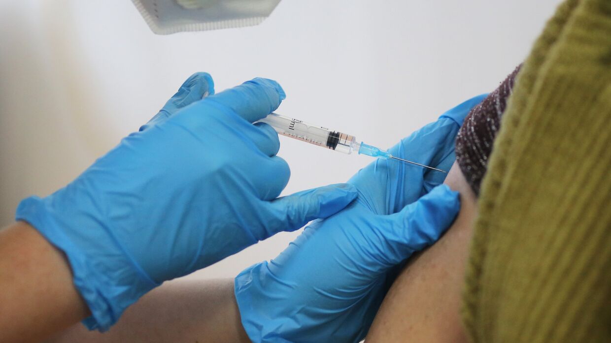 Медсестра делает прививку пациенту от коронавируса вакциной «Спутник-V» («Гам-КОВИД-Вак») в районной больнице в Волгограде