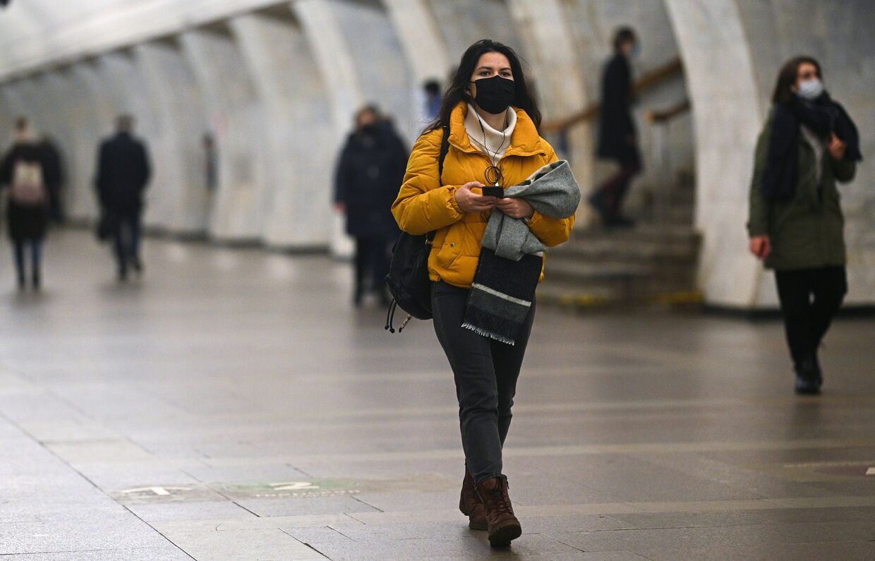 Девушка в защитной маске на одной из станций Московского метрополитена