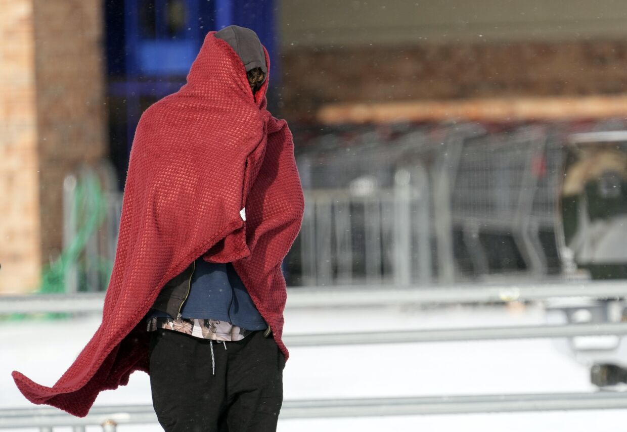 Мужчина в одеяле во время аномальных холодов в Хьюстоне, Техас, США