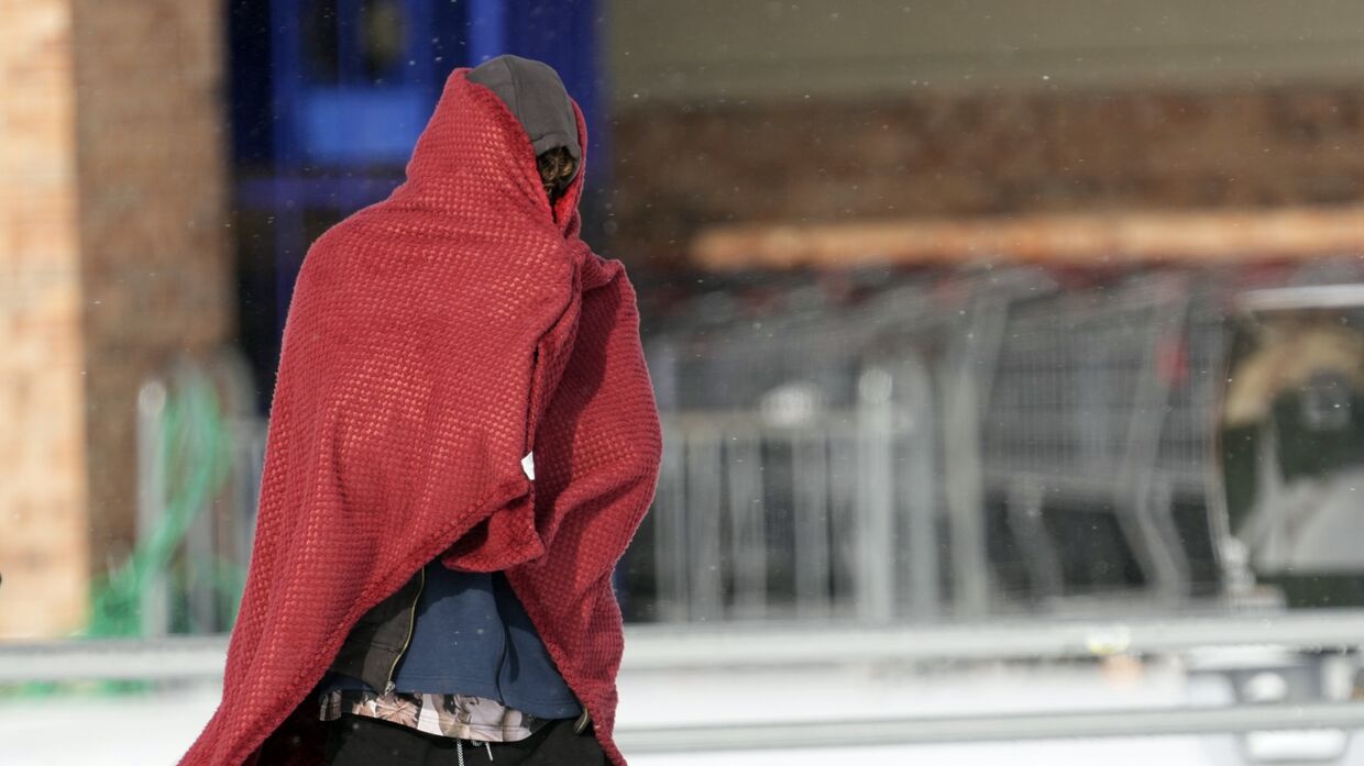 Мужчина в одеяле во время аномальных холодов в Хьюстоне, Техас, США