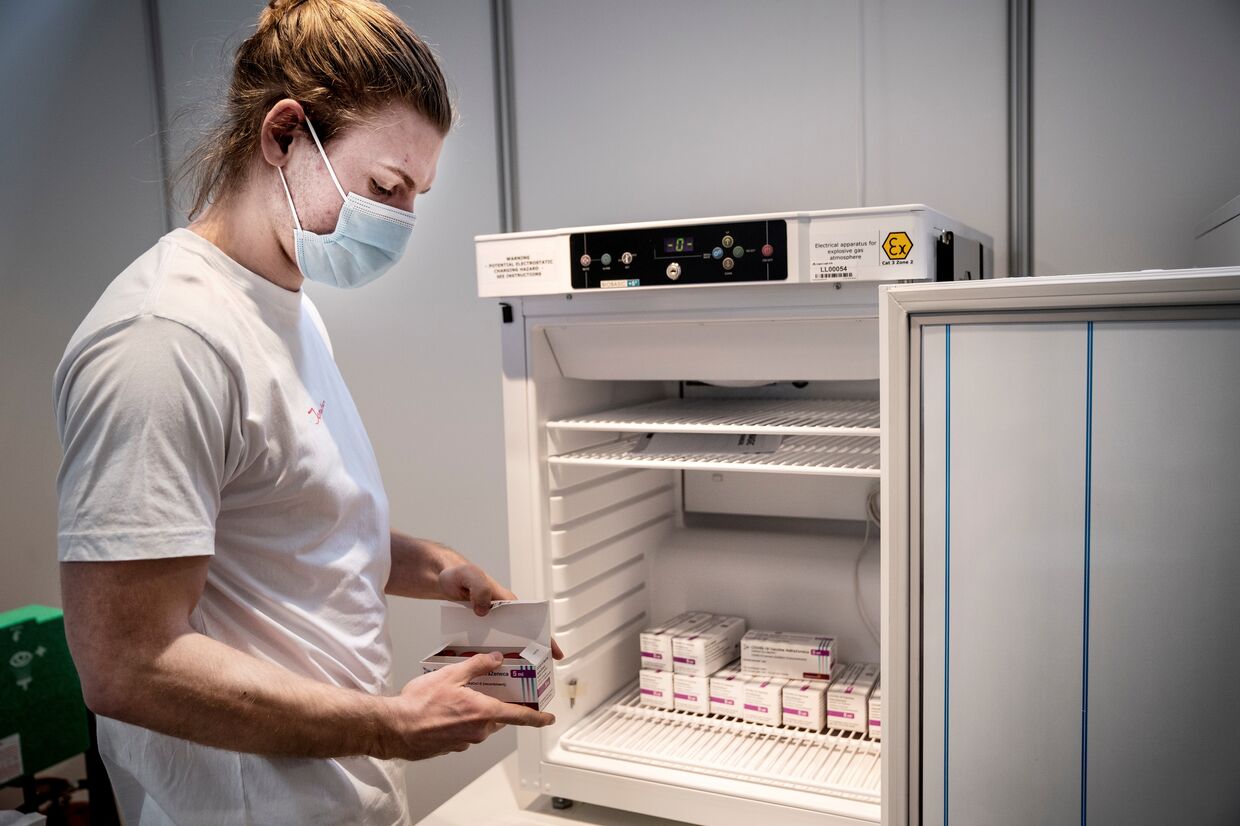 Медработник убирает вакцину от AstraZeneca на хранение в связи с приостановкой вакцинации, Копенгаген, Дания