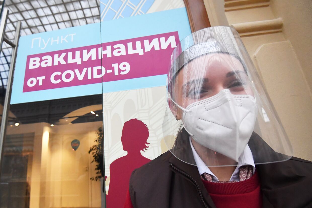 Девушка в защитной маске возле пункта вакцинации от коронавируса в ГУМе в Москве