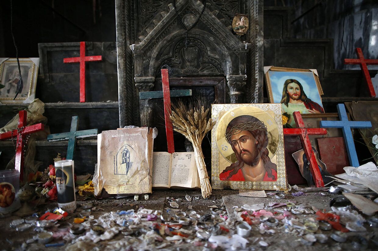 Распятия и иконы в поврежденной церкви Непорочного Зачатия в Каракоше, Ирак