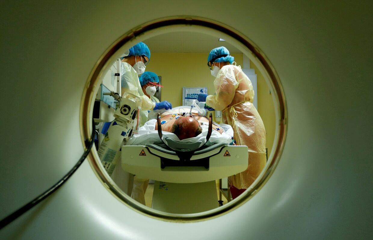 Медперсонал в защитных костюмах оказывает помощь пациенту с коронавирусом, Берлин, Германия