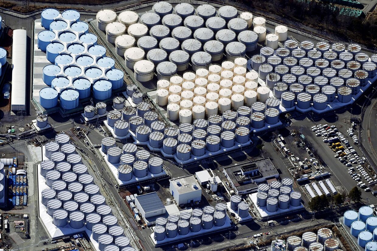 Резервуары для хранения очищенной воды на разрушенной цунами атомной электростанции Фукусима, Япония