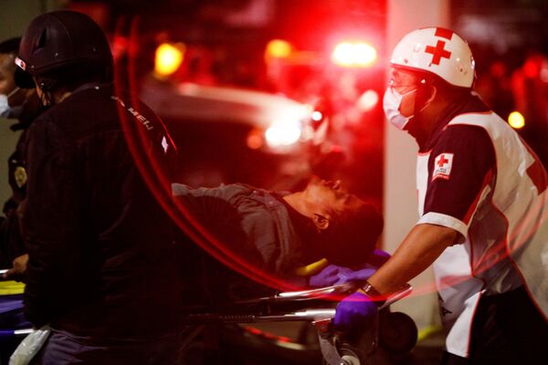 Спасатели и медицинский персонал эвакуируют пострадавших во время обрушения метромоста в Мехико, Мексика
