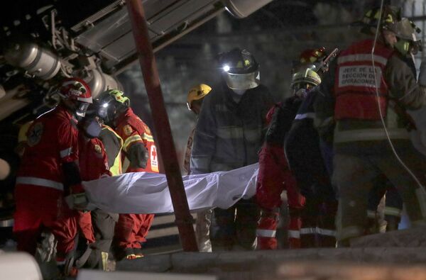 Спасатели выносят тело одной из жертв крушения поезда метро в Мехико, Мексика