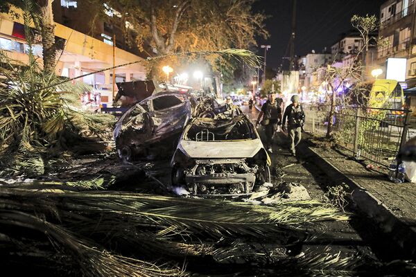 Автомобили, сгоревшие в результате ракетного обстрела в городе Холон в пригороде Тель-Авива