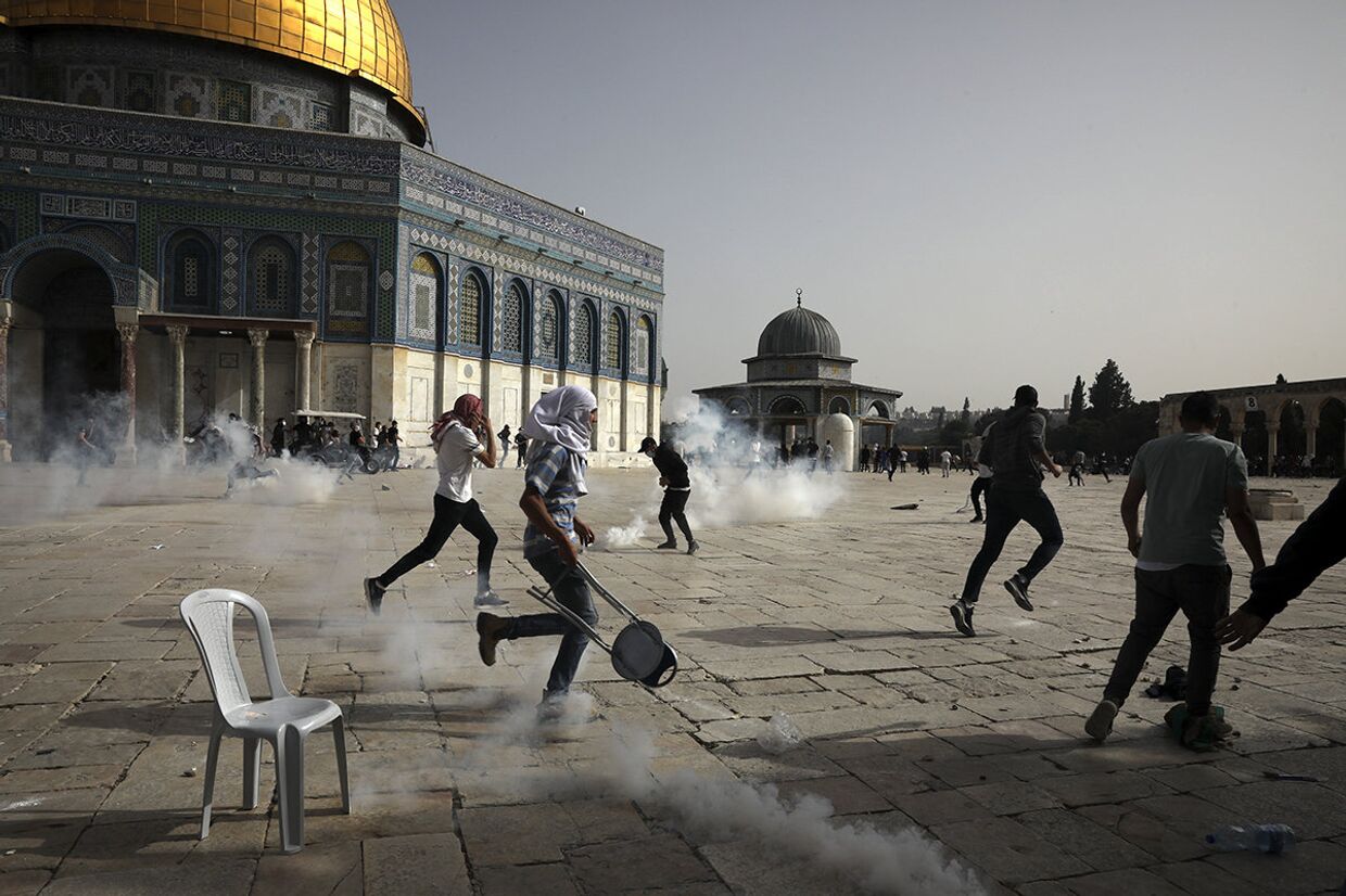 Палестинцы во время столкновений с израильскими силами безопасности у мечети Аль-Акса в Иерусалиме