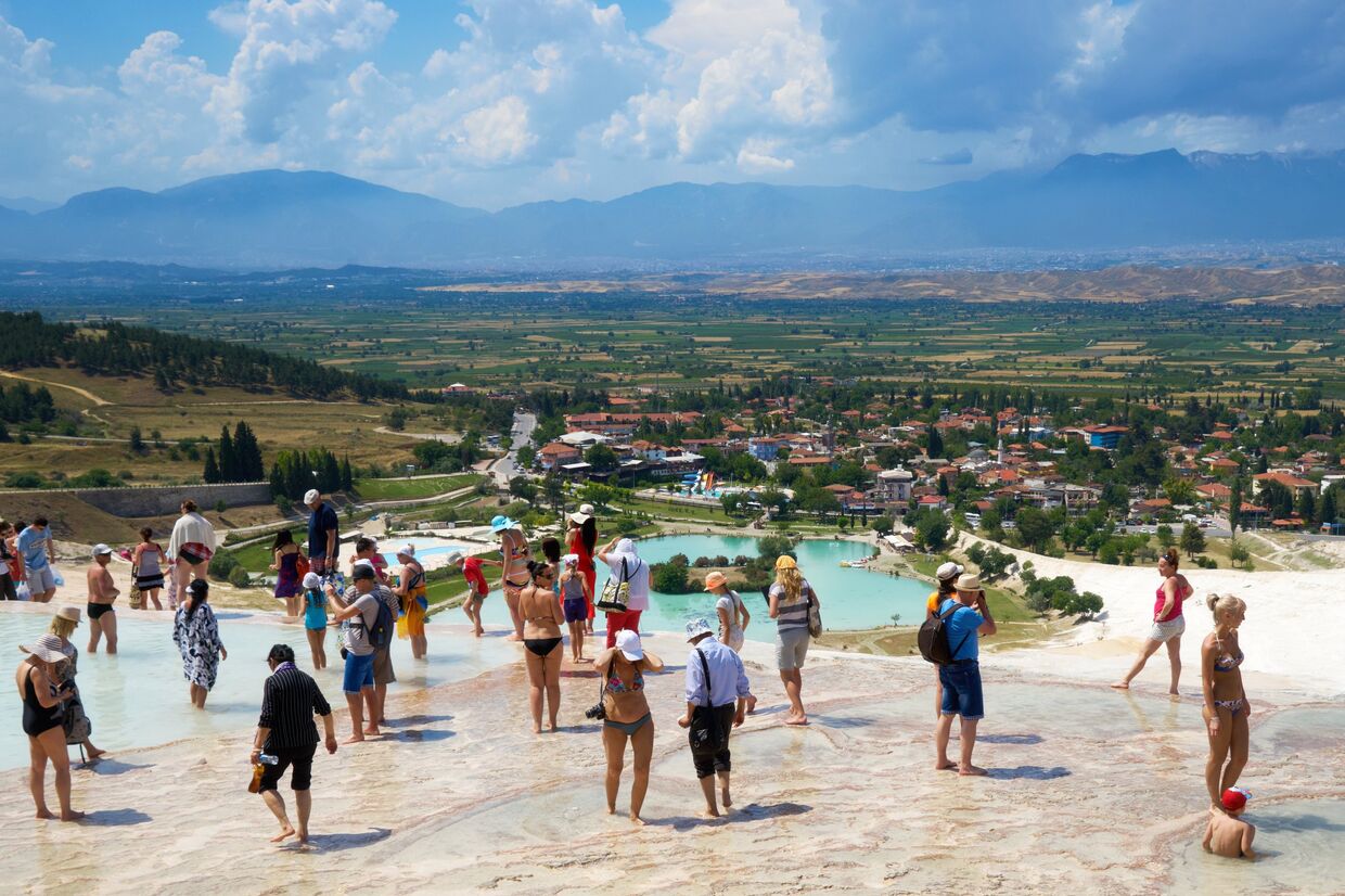 Туристы в травертинах — природных известковых бассейнах в Памуккале на юго-западе Турции
