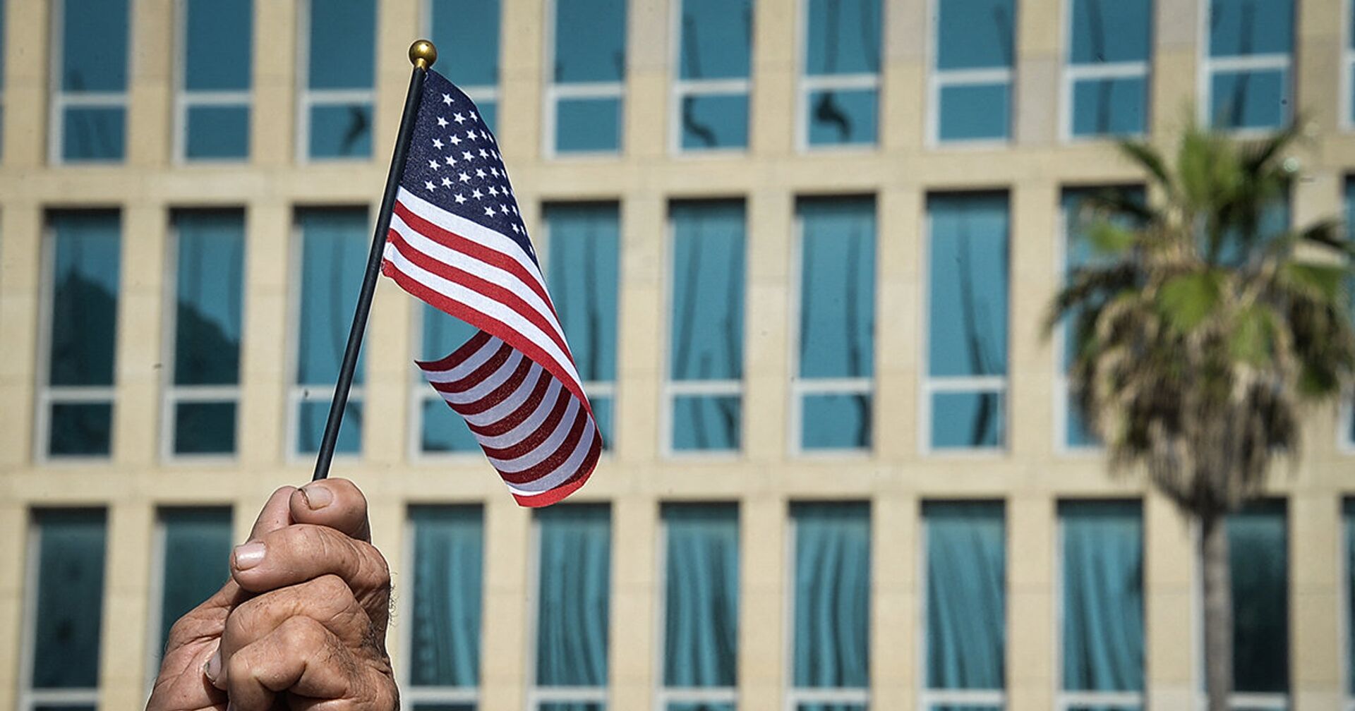 Американский флаг в руке кубинца у посольства США в Гаване - ИноСМИ, 1920, 13.05.2021