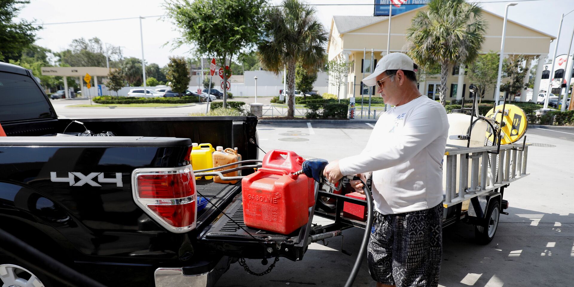 Мужчина наполняет канистры бензином на одной из немногочисленных работающих после кибератаки на трубопровод АЗС во Флориде, США - ИноСМИ, 1920, 05.06.2021