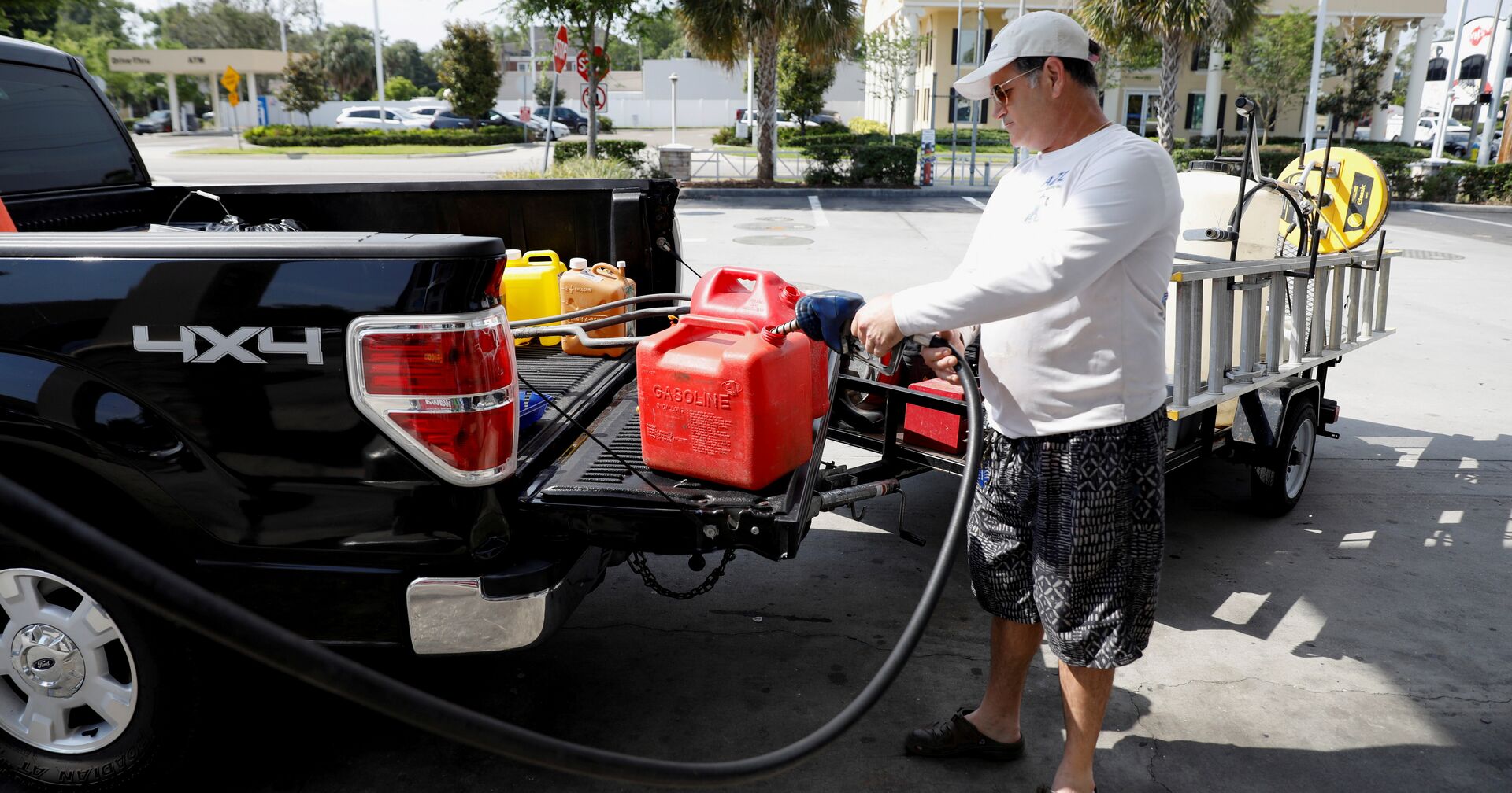 Мужчина наполняет канистры бензином на одной из немногочисленных работающих после кибератаки на трубопровод АЗС во Флориде, США - ИноСМИ, 1920, 05.06.2021