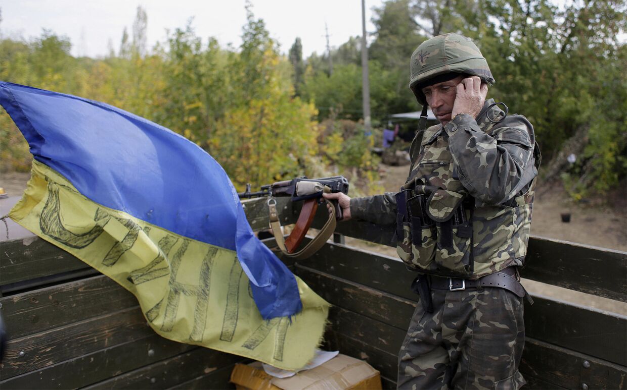 Украинский военнослужащий разговаривает по мобильному телефону на позиции вблизи города Первомайск Луганской области