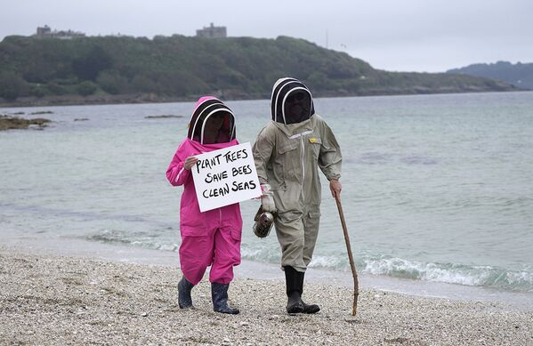 Климатические активисты на пляже в Фалмуте, Корнуолл