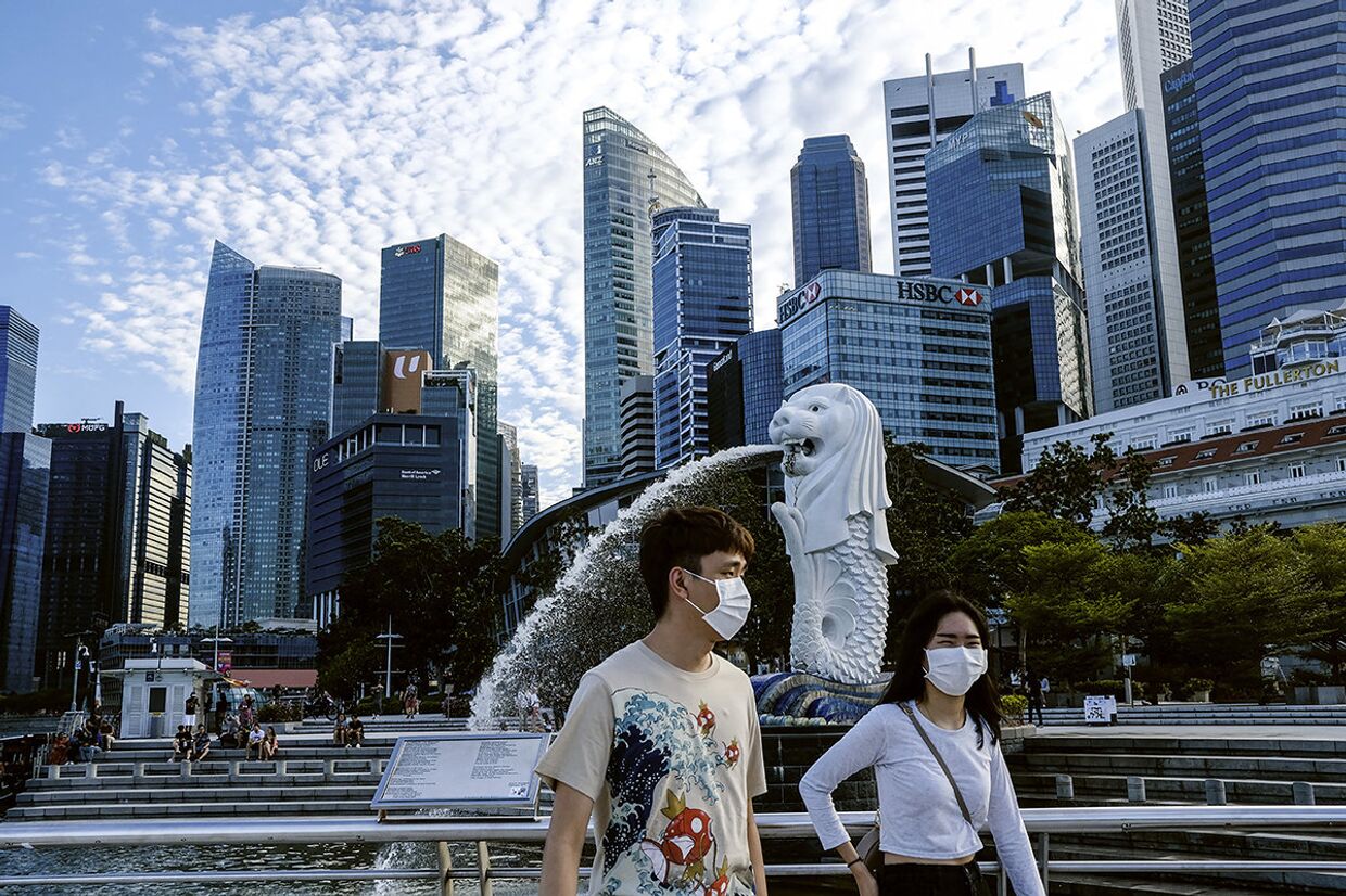 Прохожие у статуи Мерлайона в Сингапуре