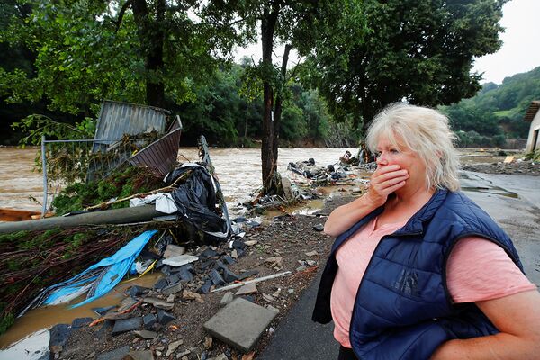 Местная жительница осматривает последствия сильного наводнения в Шульде