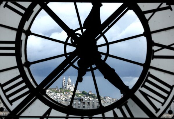 Вид на базилику Сакре-Кёр через гигантские часы музея Орсе в Париже