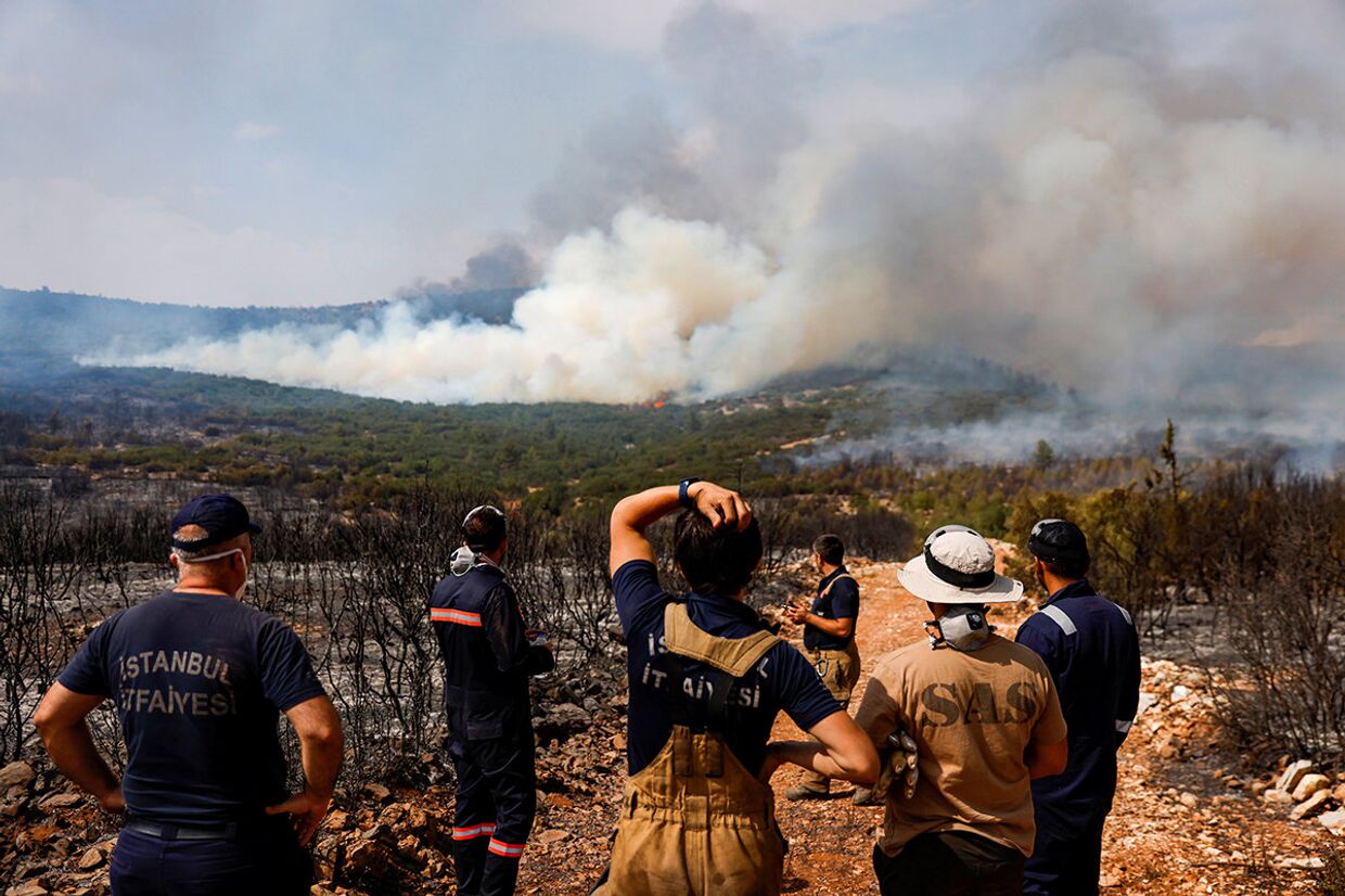 Пожарные и волонтеры готовятся к тушению лесных пожаров близ деревни Икизче в Турции