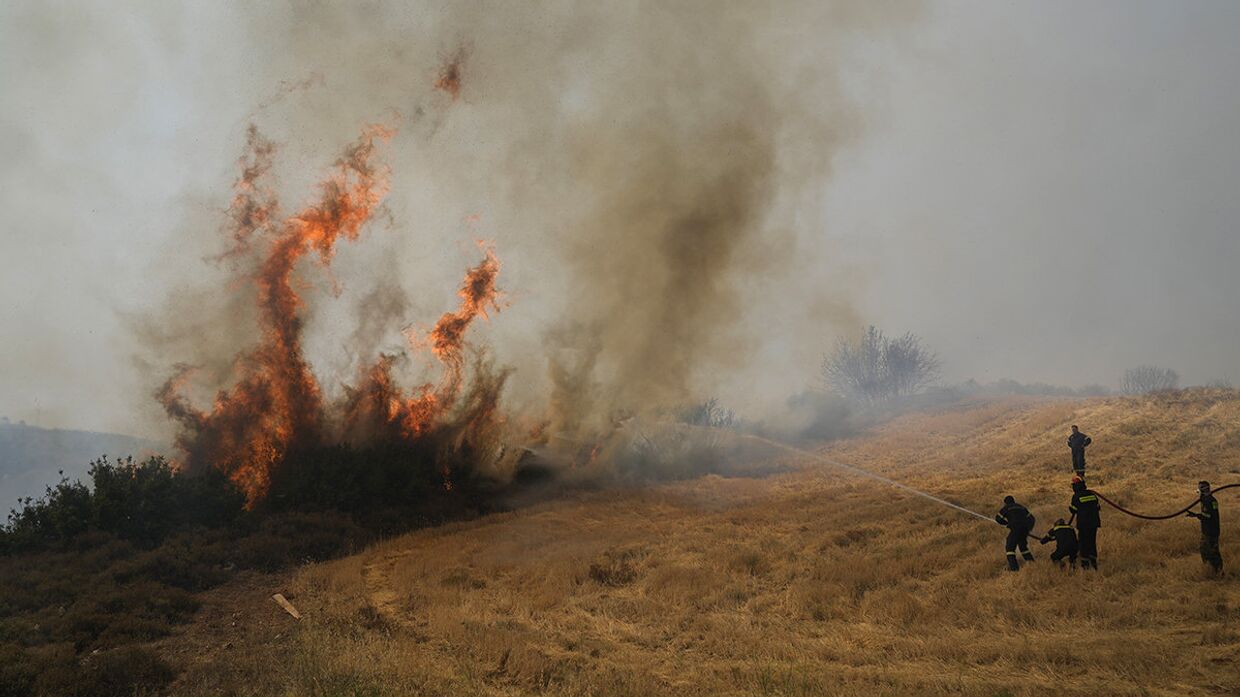Греция. Пожарные пытаются погасить пламя в поселке Айос Стефанос