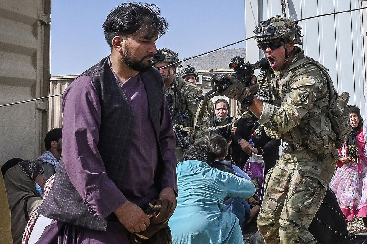 Американский солдат целится в афганцев в аэропорту Кабула