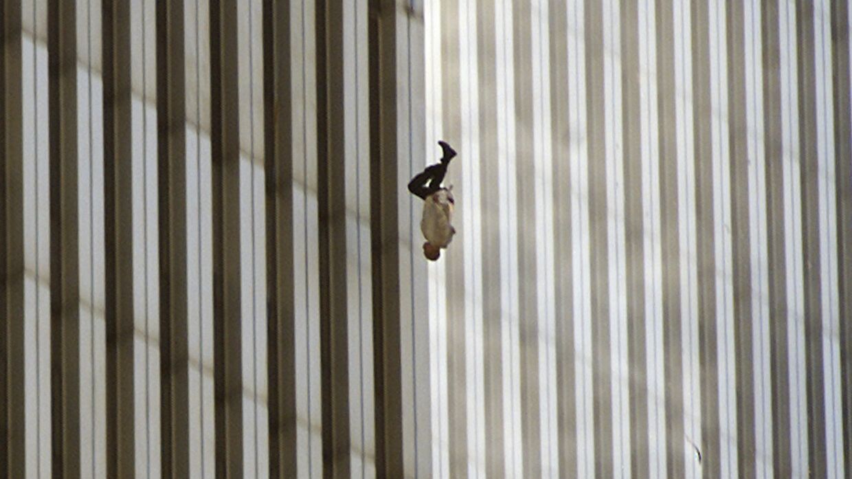 Человек падает с северной башни Всемирного торгового центра в Нью-Йорке
