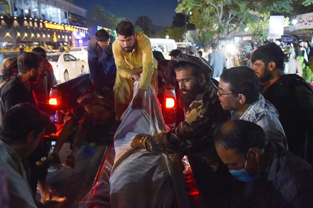 Волонтеры и медицинский персонал выгружают тела после двух мощных взрывов возле аэропорта в Кабуле