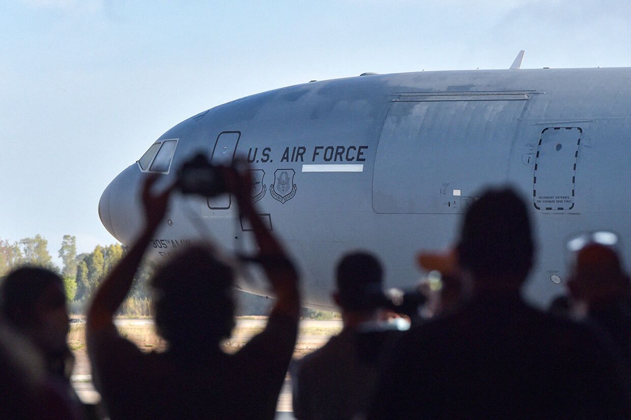 Представители СМИ фотографируют самолет ВВС США в аэропорту Кабула