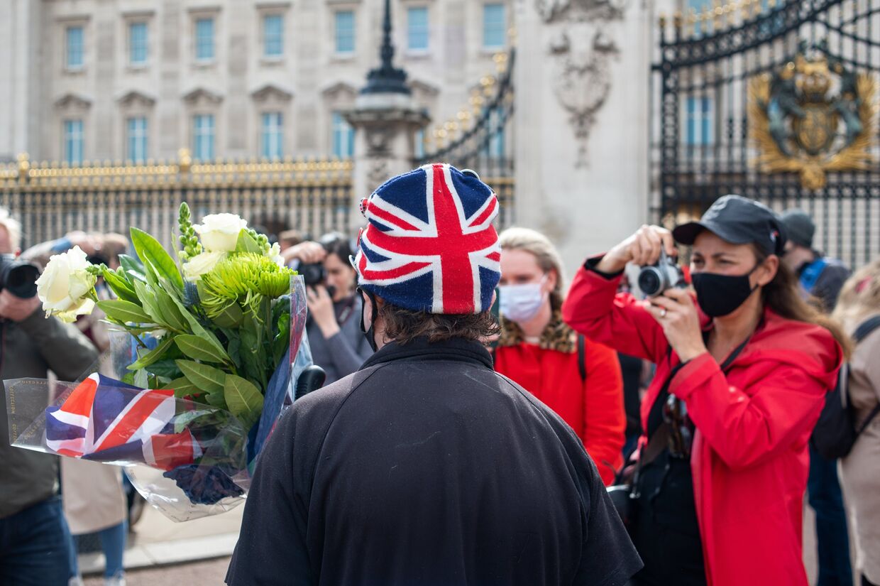 Люди несут цветы к Букингемскому дворцу в Лондоне