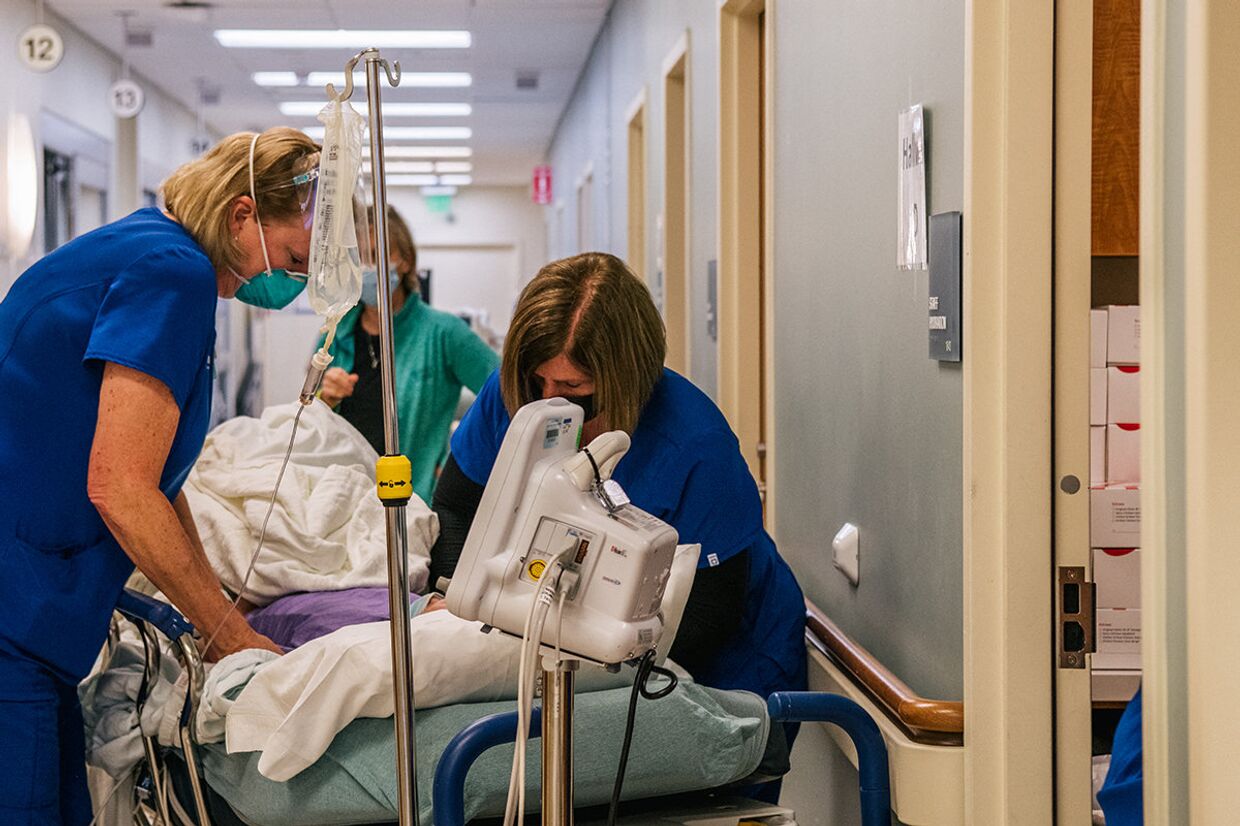 Медсестры отделения неотложной помощи ухаживают за пациентом в коридоре Хьюстонской методистской больницы Вудлендс