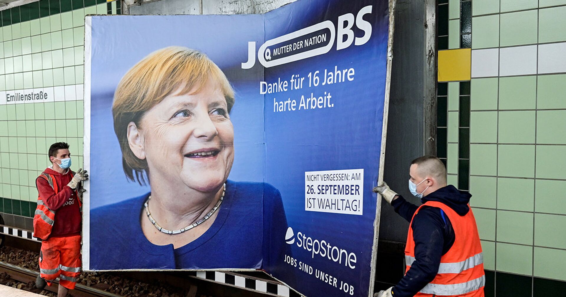 Рабочие снимают плакат с изображением канцлера Германии Ангелы Меркель - ИноСМИ, 1920, 27.09.2021