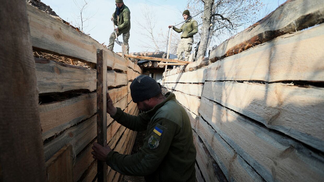 Украинские военнослужащие роют окопы недалеко от города Золотое