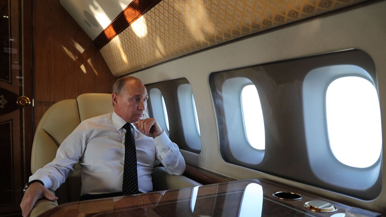 Президент РФ Владимир Путин на борту президентского самолета во время полета на авиабазу Хмеймим в Сирии