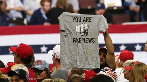Сторонники Дональда Трампа с футболкой в руках с надписью Фальшивые новости в Рочестере